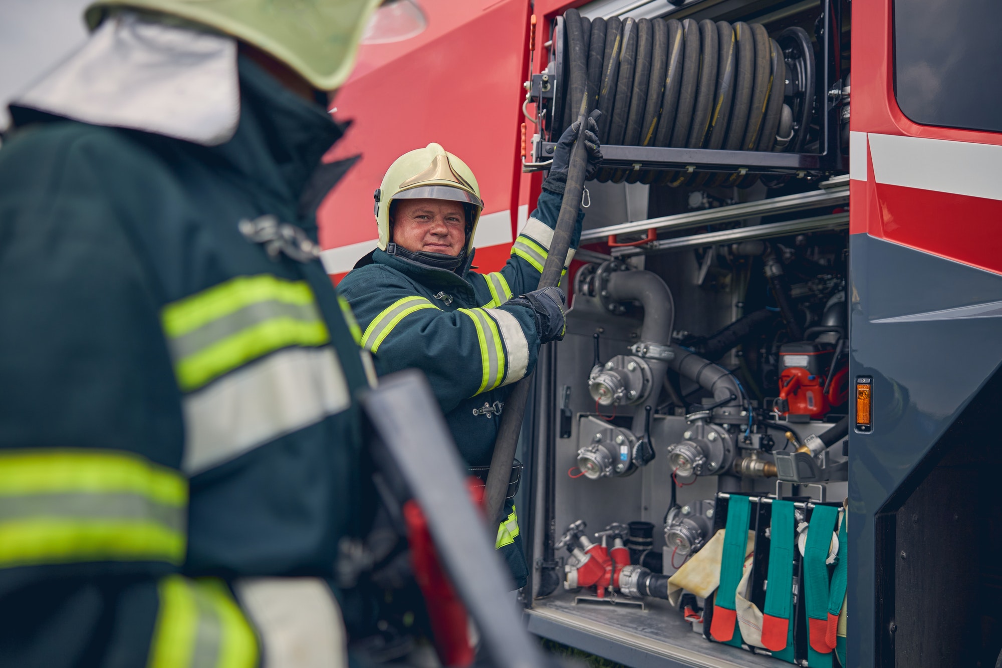 Mature firefighter training work with fire equipment